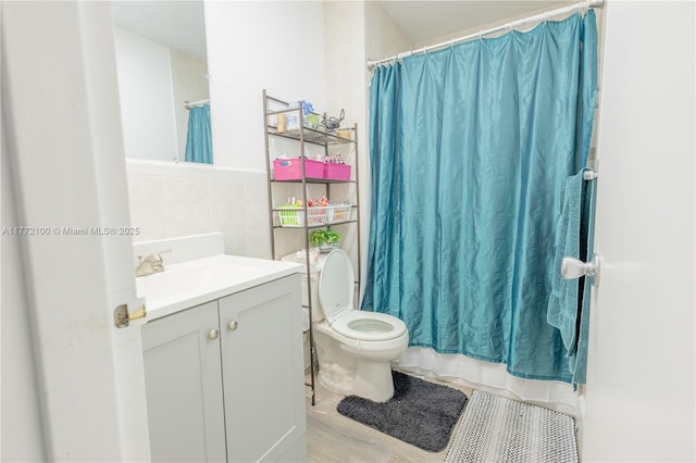 full bathroom with toilet, vanity, tile walls, and shower / bath combo