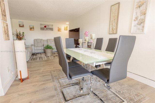 dining space featuring a textured ceiling and wood finished floors