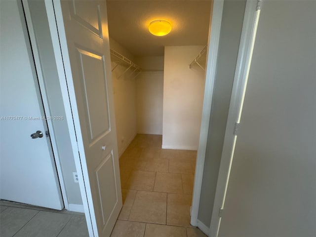 walk in closet featuring light tile patterned flooring
