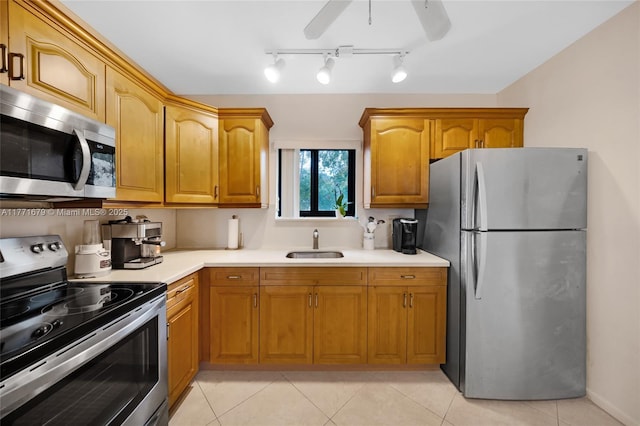 kitchen featuring a ceiling fan, light countertops, a sink, light tile patterned floors, and stainless steel appliances