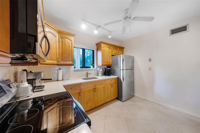 kitchen with a ceiling fan, visible vents, appliances with stainless steel finishes, a sink, and light countertops