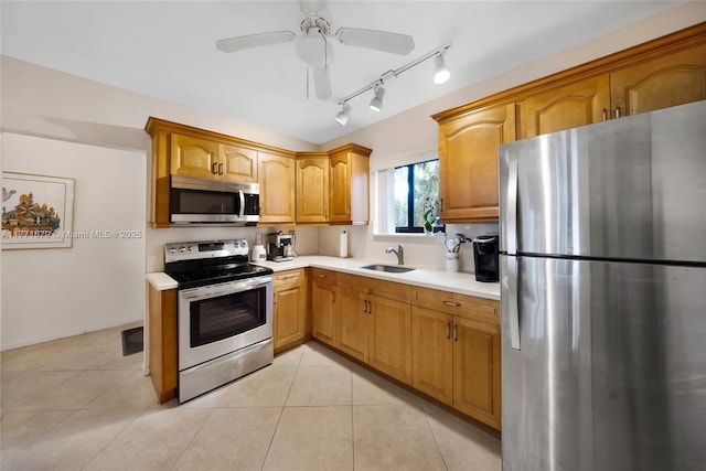 kitchen with a ceiling fan, a sink, light countertops, light tile patterned floors, and stainless steel appliances