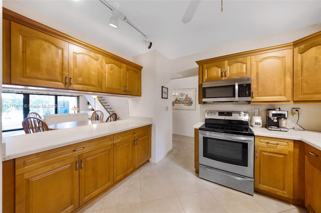 kitchen with ceiling fan, light countertops, brown cabinets, light tile patterned floors, and stainless steel appliances