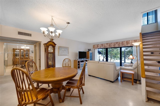 dining space featuring visible vents, a textured ceiling, stairs, and a chandelier