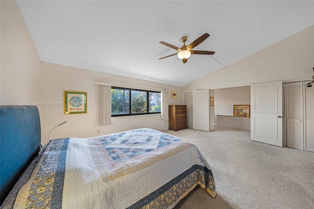 bedroom with ceiling fan, vaulted ceiling, and light carpet