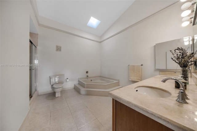 full bath featuring a sink, tile patterned flooring, vaulted ceiling with skylight, toilet, and a garden tub