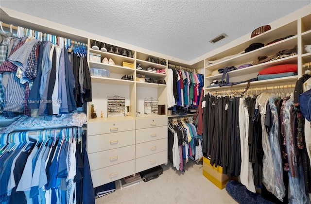 walk in closet with visible vents and carpet