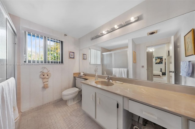 full bathroom with toilet, a shower stall, a healthy amount of sunlight, and vanity