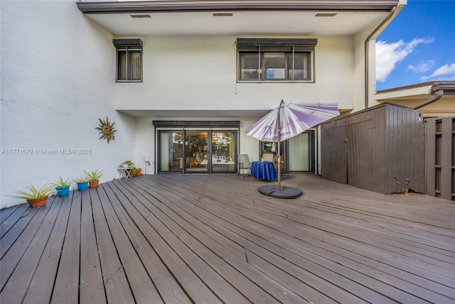 wooden deck with an outdoor structure and a shed