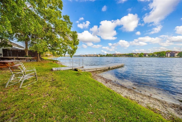 dock area featuring a lawn and a water view