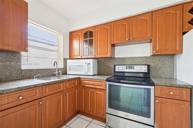 1121 SW 36th Ave, Miami, FL 33135 - kitchen with stainless steel range with electric stovetop, a sink, white microwave, and light stone countertops