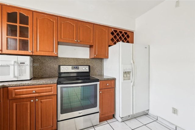 1121 SW 36th Ave, Miami, FL 33135 - kitchen featuring light tile patterned flooring, backsplash, glass insert cabinets, brown cabinetry, and white appliances