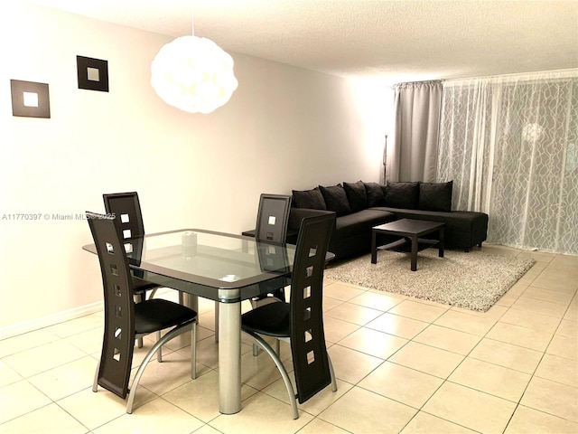 1680 NE 191st St Unit 107-2, Miami, FL 33179 - dining room with light tile patterned flooring, baseboards, and a textured ceiling