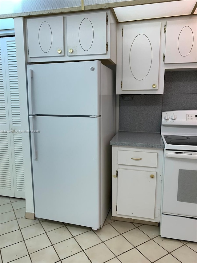 1680 NE 191st St Unit 107-2, Miami, FL 33179 - kitchen featuring light tile patterned flooring, white appliances, and white cabinetry