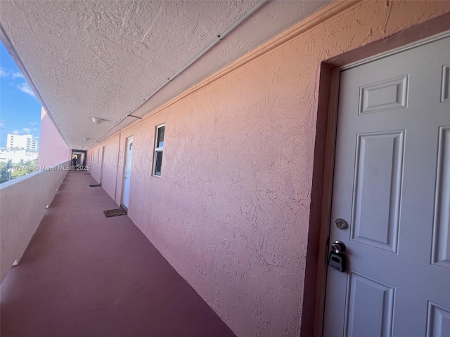 view of side of home with stucco siding and a balcony