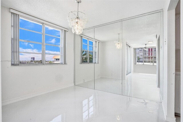3113 S Ocean Dr Unit 410, Hallandale Beach, FL 33009 - unfurnished bedroom featuring baseboards, a chandelier, and a textured ceiling
