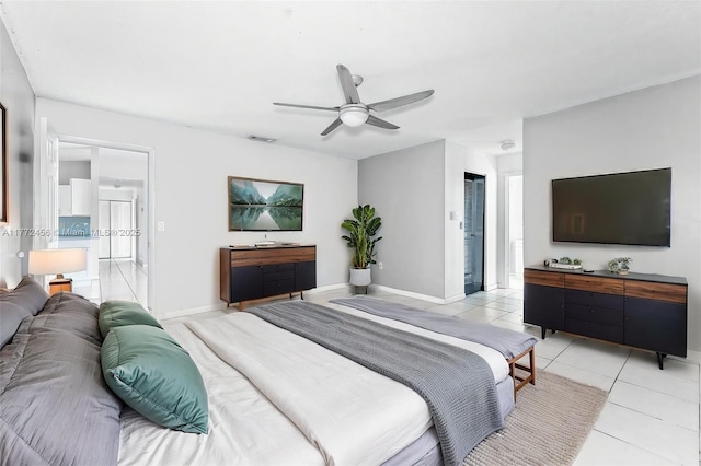 bedroom with connected bathroom, a ceiling fan, light tile patterned floors, baseboards, and visible vents