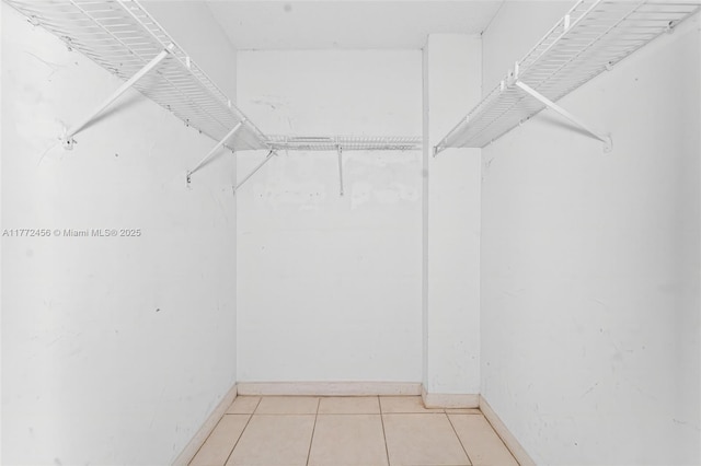 walk in closet with light tile patterned floors