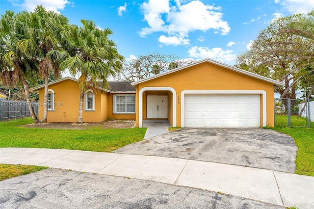 ranch-style house featuring a front yard, stucco siding, fence, and aphalt driveway