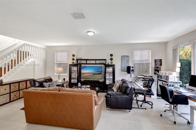 living area featuring visible vents, stairway, and light tile patterned flooring