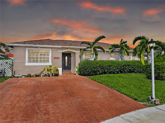 view of front of house featuring stucco siding and a front lawn