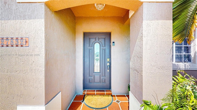 entrance to property featuring stucco siding