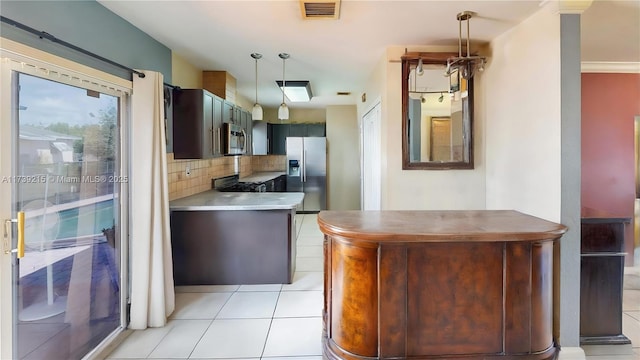 kitchen featuring hanging light fixtures, decorative backsplash, light tile patterned flooring, stainless steel appliances, and visible vents