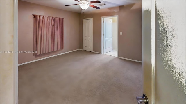 unfurnished bedroom with baseboards, a ceiling fan, visible vents, and carpet