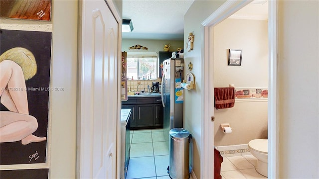 bathroom with vanity, tile patterned floors, toilet, crown molding, and baseboards