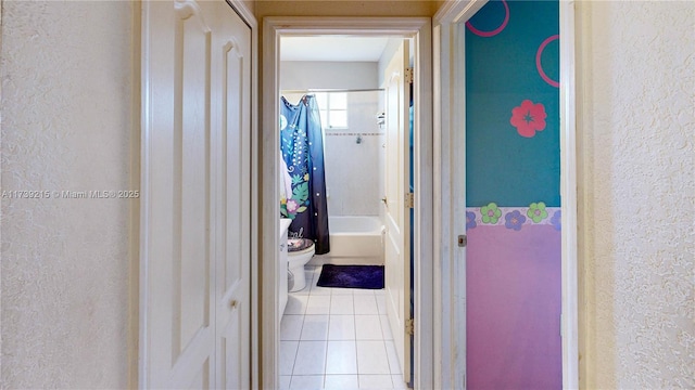 corridor with tile patterned flooring and a textured wall