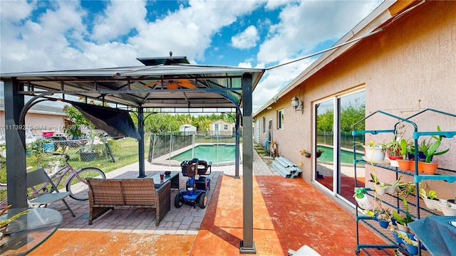 view of patio with fence, a gazebo, and a fenced in pool