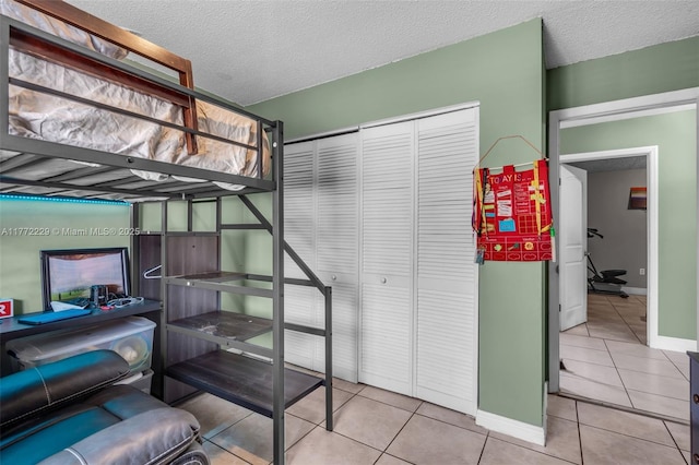 12332 NW 97th Ct, Hialeah Gardens, FL 33018 - bedroom with tile patterned floors, a closet, baseboards, and a textured ceiling