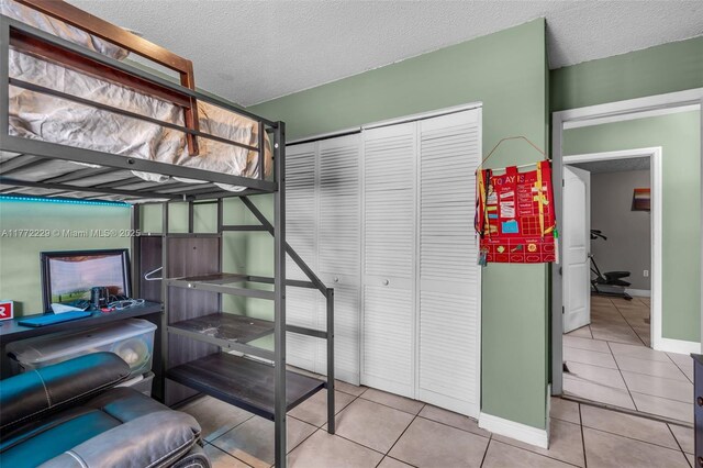12332 NW 97th Ct, Hialeah Gardens, FL 33018 - bedroom with tile patterned floors, a closet, baseboards, and a textured ceiling