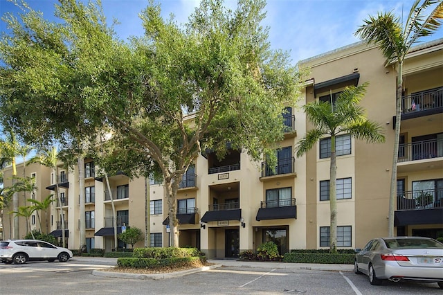 view of apartment building / complex with uncovered parking