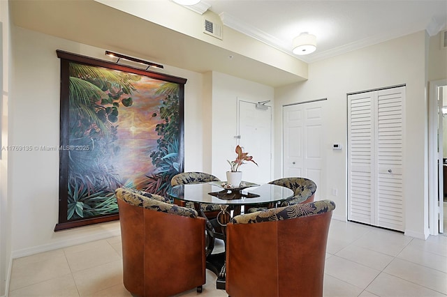 dining space featuring crown molding, light tile patterned floors, and baseboards