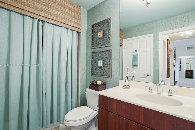 full bath with wallpapered walls, toilet, and vanity