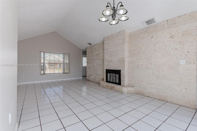 unfurnished living room with lofted ceiling, an inviting chandelier, light tile patterned floors, visible vents, and a fireplace