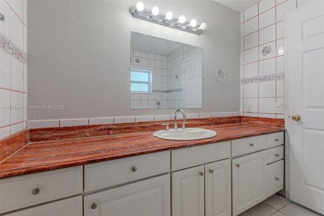 bathroom with tile walls, a tile shower, tile patterned flooring, and vanity