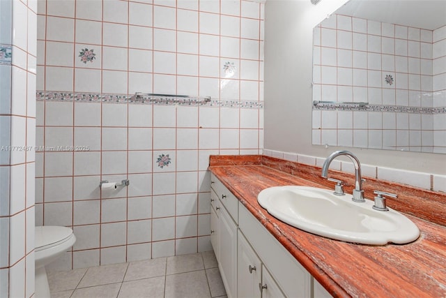 bathroom with tile walls, toilet, tile patterned floors, and vanity