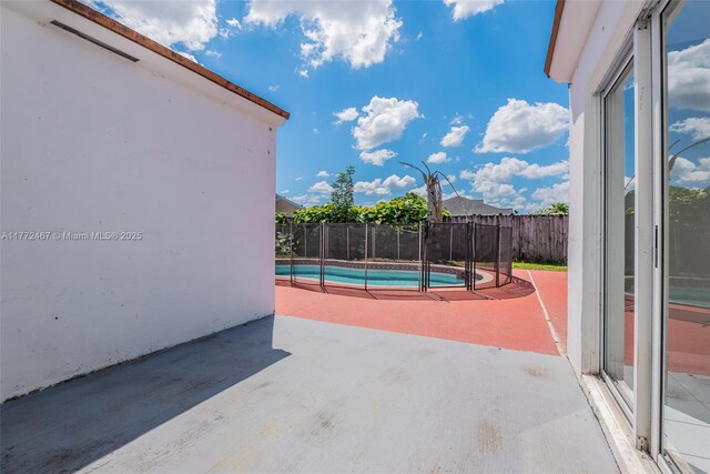 view of patio with fence and a fenced in pool