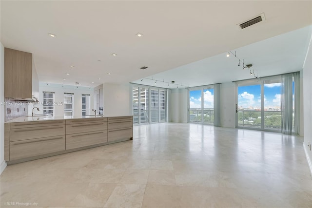 2645 S Bayshore Dr Unit 902, Miami, FL 33133 - unfurnished living room featuring a sink, floor to ceiling windows, and track lighting