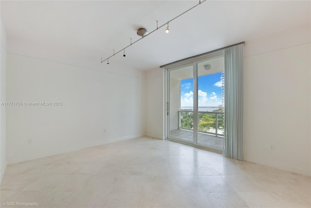 2645 S Bayshore Dr Unit 902, Miami, FL 33133 - empty room with floor to ceiling windows, rail lighting, baseboards, and light tile patterned flooring
