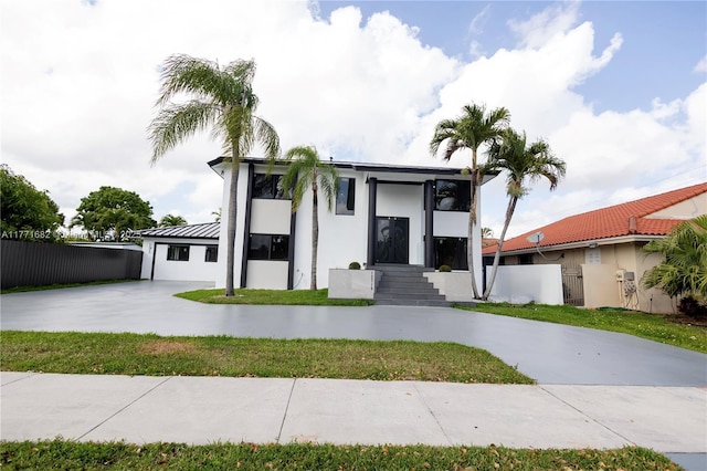 contemporary home featuring stucco siding, fence, and concrete driveway