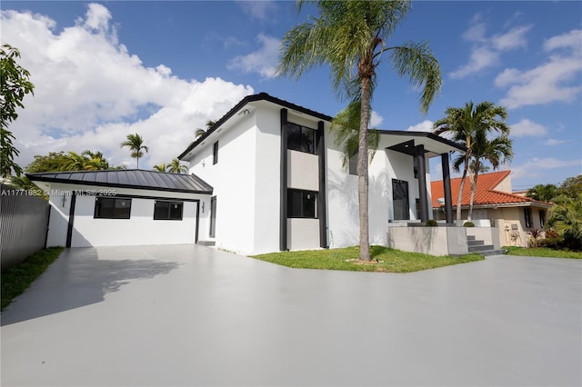 view of front of property featuring stucco siding, fence, and concrete driveway