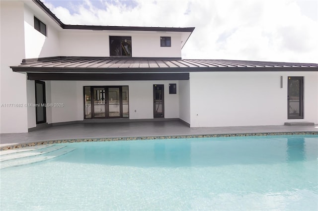back of property featuring a patio, metal roof, a standing seam roof, and stucco siding