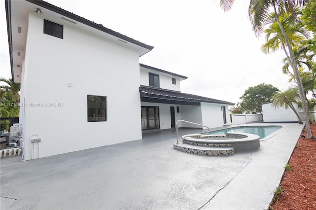 exterior space with fence, french doors, a pool with connected hot tub, and a patio area
