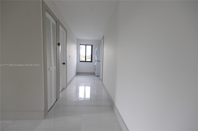 corridor with baseboards and light tile patterned floors