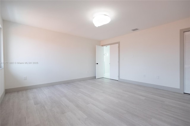 unfurnished room with visible vents, baseboards, and light wood-type flooring