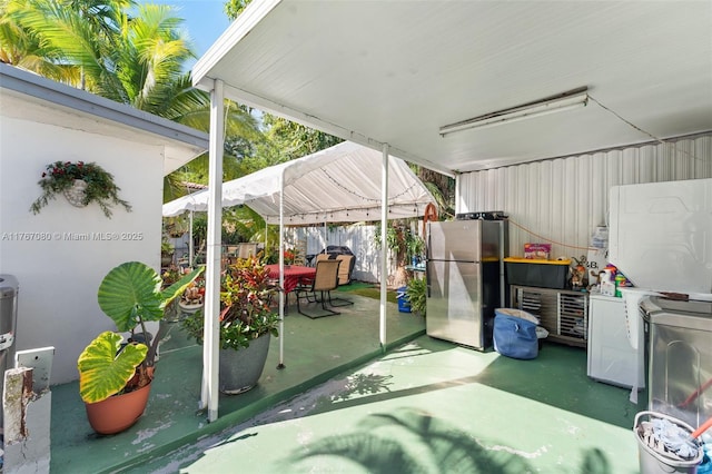 view of patio featuring a gazebo, outdoor dining space, and fence