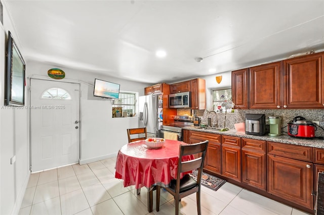 kitchen with decorative backsplash, stainless steel appliances, a sink, and a healthy amount of sunlight